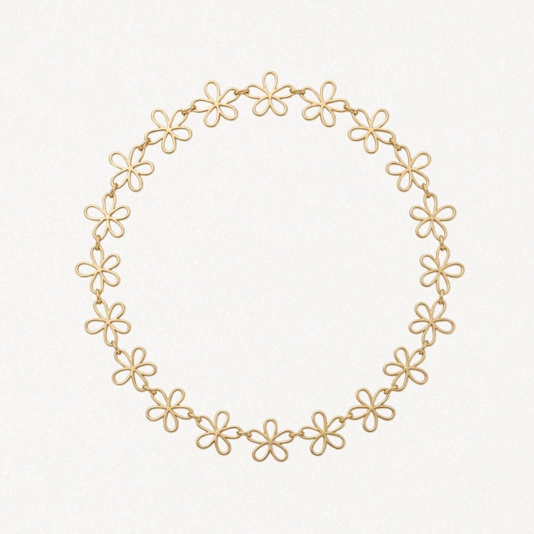 Collier en acier inoxydable doré à maillons fleurs ajourées, formant un cercle.