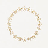 Collier en acier inoxydable doré à maillons fleurs ajourées, formant un cercle.