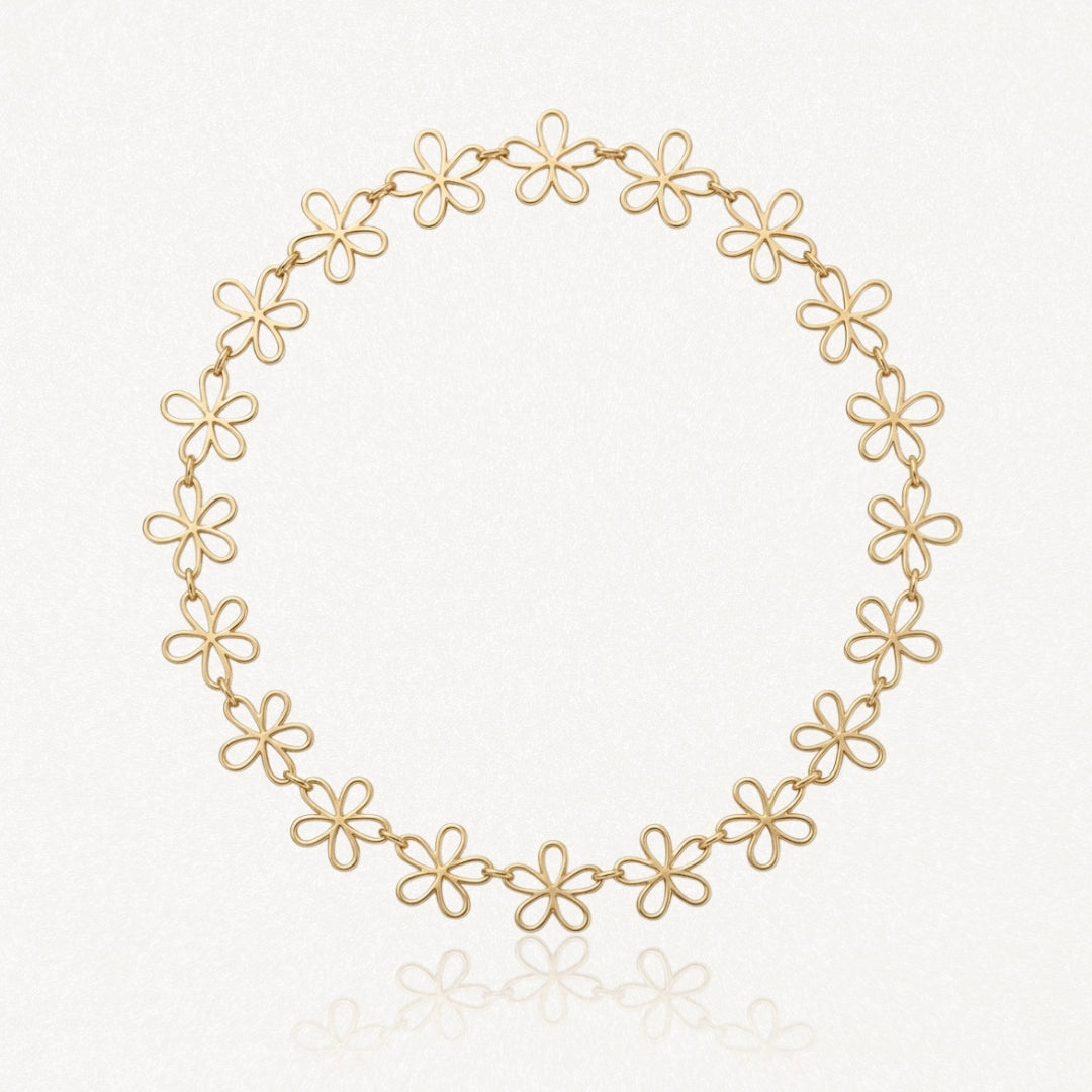 Collier en acier inoxydable doré, composé de maillons ajourés en forme de fleurs, sur fond blanc.