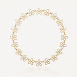 Collier en acier inoxydable doré, composé de maillons ajourés en forme de fleurs, sur fond blanc.
