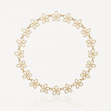 Collier en acier inoxydable doré, composé de maillons ajourés en forme de fleurs, sur fond blanc.