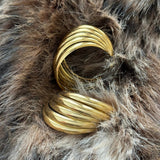 Boucles d'oreilles créoles épaisses posées sur de la fausse fourrure, inspiration accessoire mode automne-hiver.