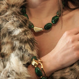 Détail de la parure portée : collier et bracelet MAISON DE L'AMOUR en perles vertes et acier inoxydable doré, texture fourrure.