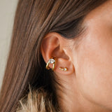 Earcuff mini-créoles doubles en acier inoxydable doré avec zirconium goutte, porté sur une oreille avec 3 mini clous zircon.
