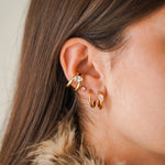 Oreille avec bague d'oreille double et boucles mini-créoles, toutes en acier inoxydable doré et zirconium.