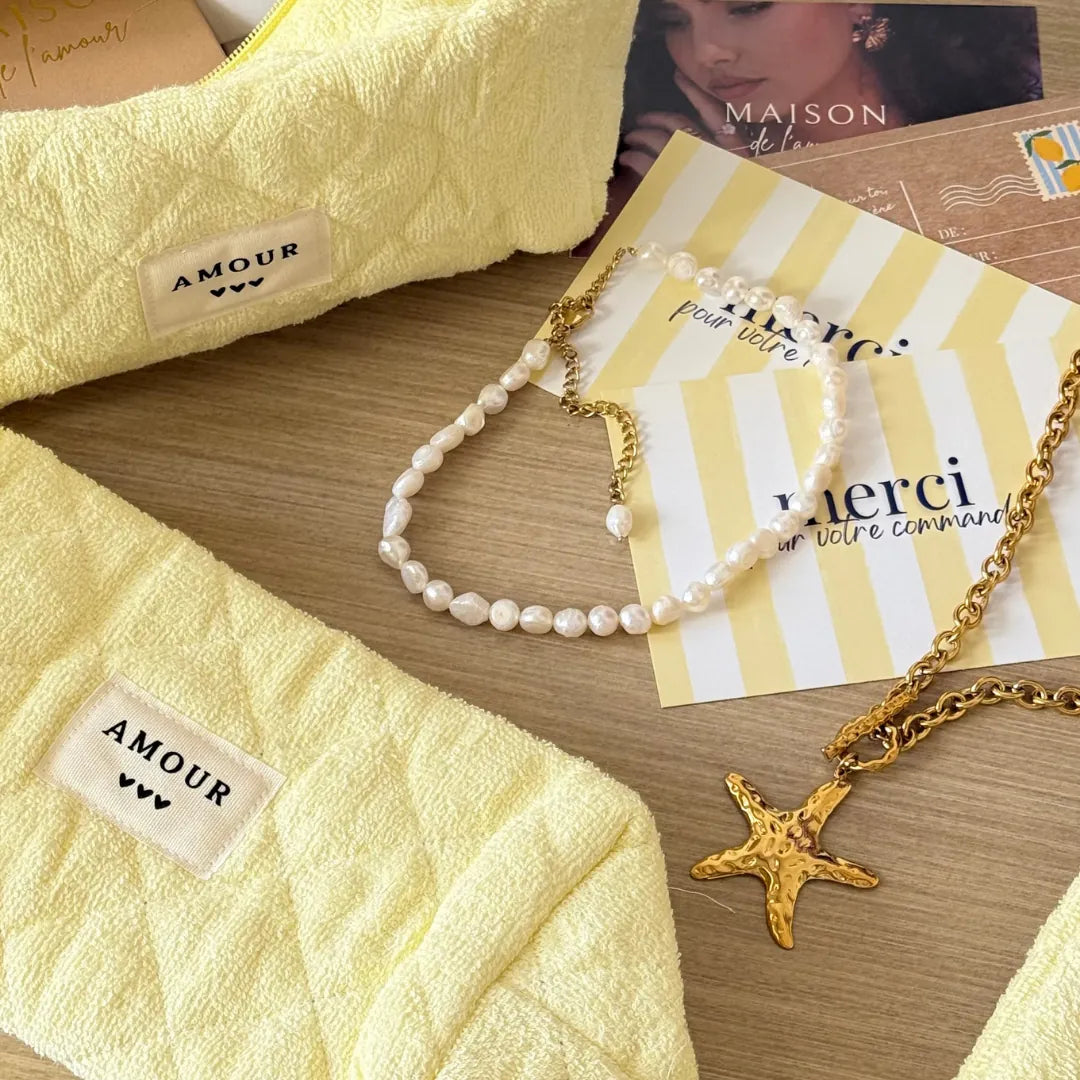 Deux pochettes jaunes polyester effet éponge matelassé, label AMOUR. Collier perles et acier inoxydable dore étoile de mer.
