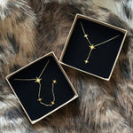 Duo de colliers étoiles MAISON DE L'AMOUR présentés dans leurs boîtes cadeaux, suggestion d'achat pour Noël ou anniversaire.