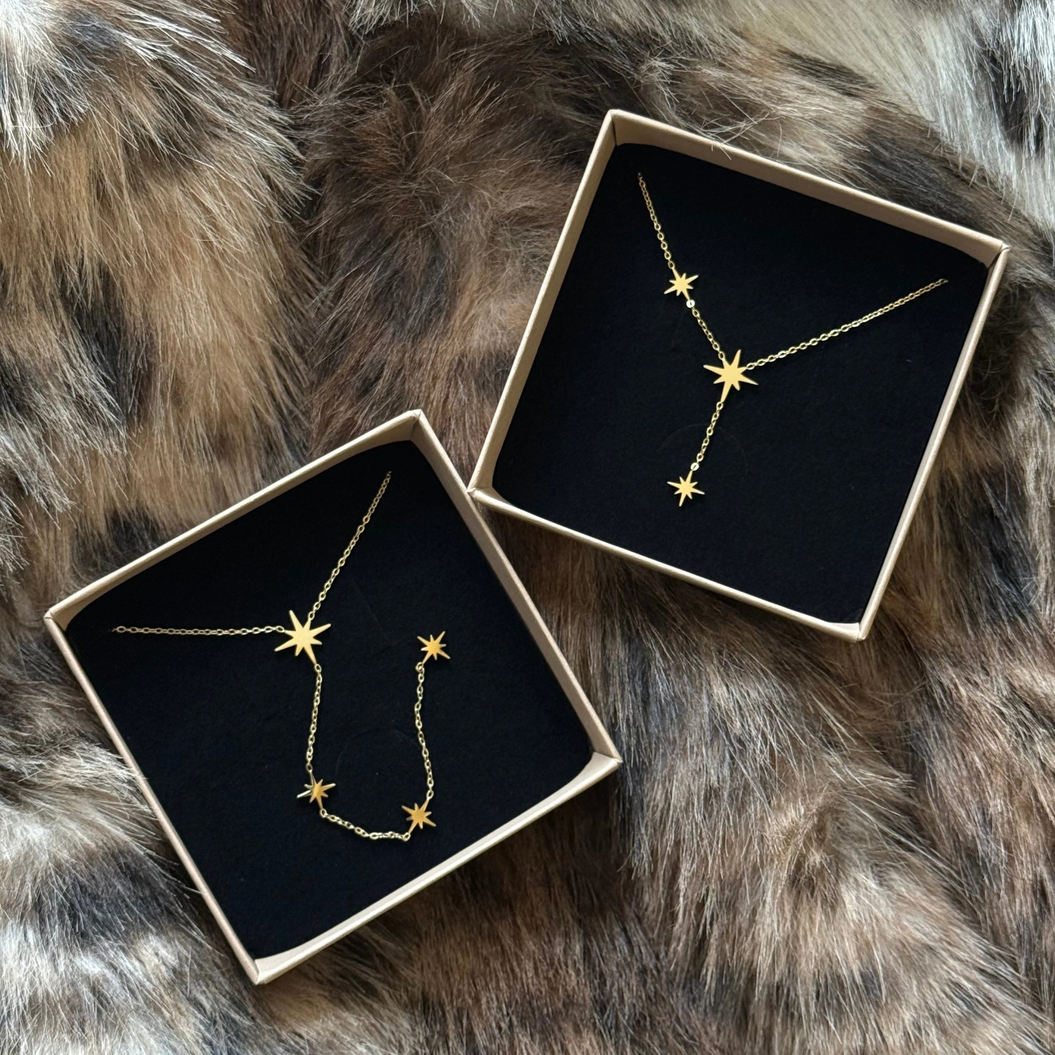 Duo de colliers étoiles MAISON DE L'AMOUR présentés dans leurs boîtes cadeaux, suggestion d'achat pour Noël ou anniversaire.