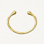 Vue de dessus d'un bracelet jonc ouvert doré montrant sa forme ovale ergonomique et ses finitions lisses.