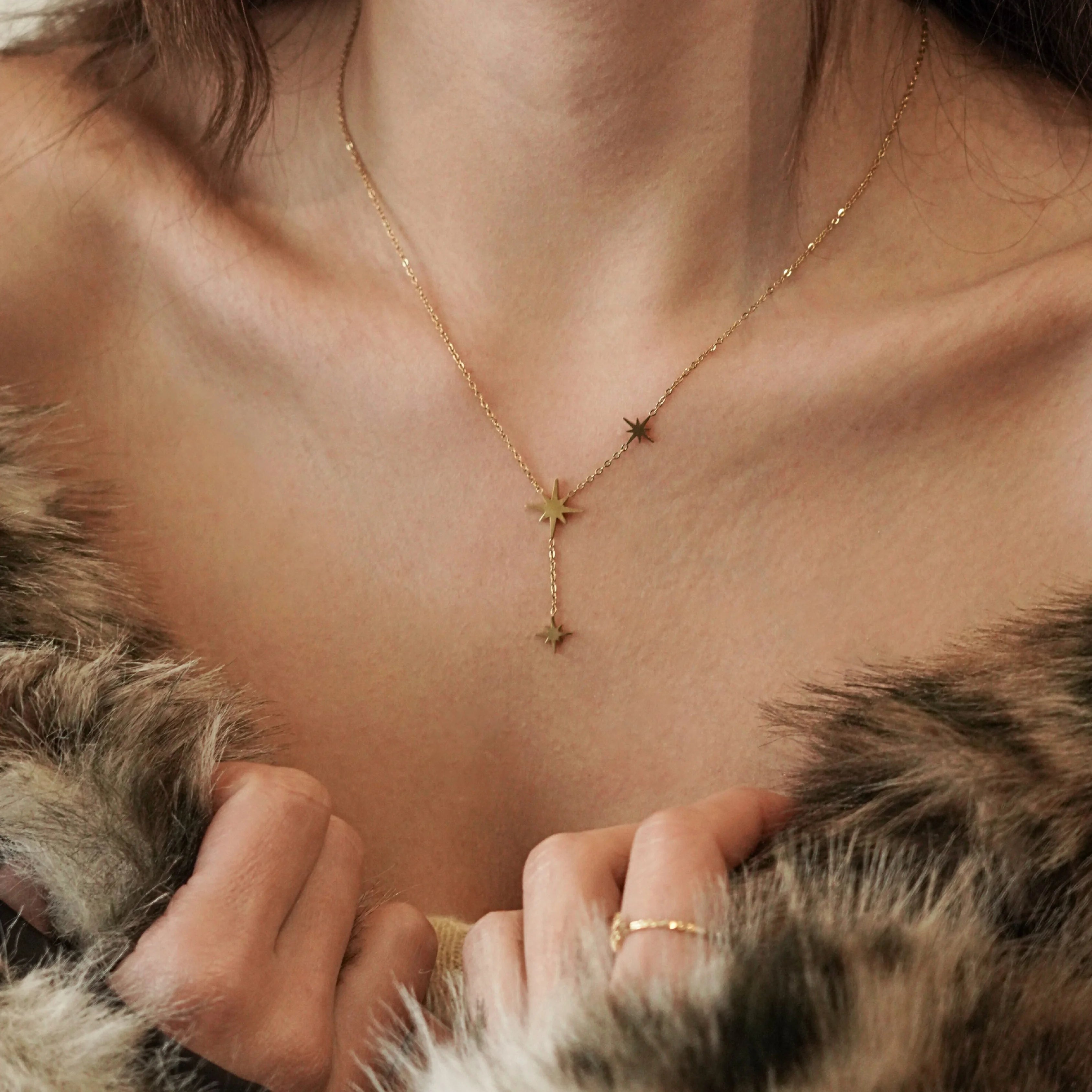 Collier étoiles MAISON DE L'AMOUR porté avec un manteau en fausse fourrure, inspiration bijou de soirée et fêtes.