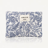 Pochette matelassée à motifs floraux et végétaux bleus sur blanc. Fermeture éclair, et étiquette "AMOUR" avec 3 cœurs.