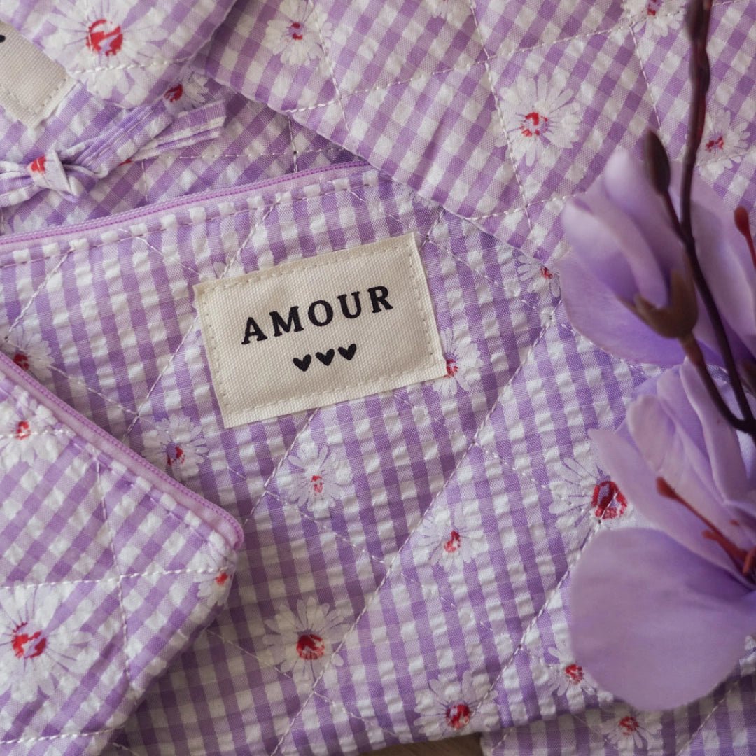 Ambiance douce pour bague en acier inoxydable: tissu vichy violet marguerites, étiquette AMOUR, fleurs violettes.