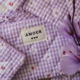 Ambiance douce pour bague en acier inoxydable: tissu vichy violet marguerites, étiquette AMOUR, fleurs violettes.