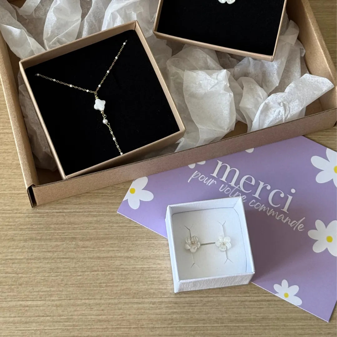 Paire de puces d'oreilles fleurs en nacre et acier inoxydable doré, dans un écrin blanc. Carte "merci" et coffret cadeau avec