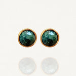 Paire de puces d'oreilles minimalistes MAISON DE L'AMOUR : pierre verte effet émeraude sertie de métal doré sur fond blanc.